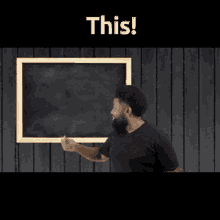 a man with a beard is standing in front of a blackboard that says this on it