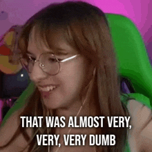 a woman wearing glasses is smiling and saying `` that was almost very very dumb '' .