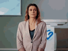 a woman in a suit stands in front of a hp sign