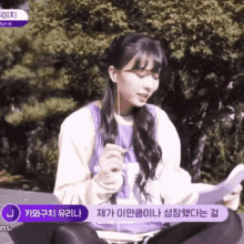a girl wearing ear buds is sitting on a bench with a purple sticker that says j on it