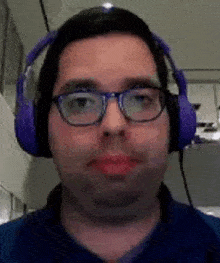 a man wearing glasses and headphones is looking at the camera .