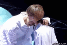 a photo of a man kissing another man with marigold jin written on the bottom right