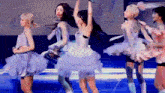 a group of young women are dancing on a stage in tutus .