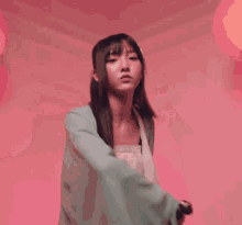 a woman in a kimono is holding a sword in her hand .