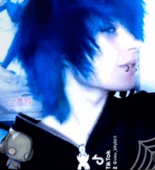 a person with blue hair is wearing a black hoodie and a black choker .