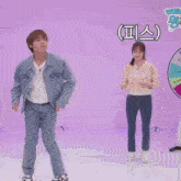 a man and a woman are dancing in front of a wheel with korean writing on it