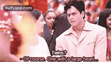 a man and a woman are standing next to each other and the man is asking the woman if she is a twin .