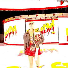 a woman in a red plaid skirt is holding a wrestling belt