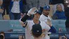 a baseball player wearing a dodgers uniform is waving to the crowd