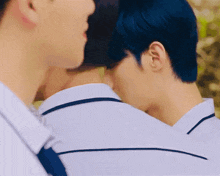 a man with blue hair kissing another man 's neck