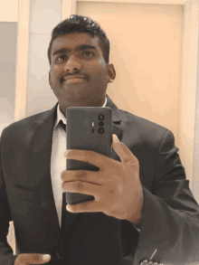 a man in a suit is taking a picture of himself
