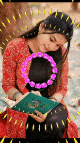 a woman in a red jacket is reading a book surrounded by purple flowers .