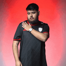 a man with a beard is wearing an adidas shirt and a watch