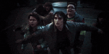 a group of people are walking down a dark street