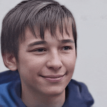 a young man with a blue shirt on smiles for the camera