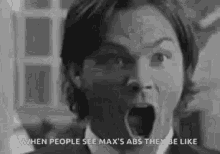 a man in a suit and tie is screaming with his mouth open .