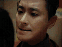 a close up of a man 's face with a slight smile