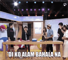 a group of people standing around a table that says ' di ko alam bahala na ' on the bottom