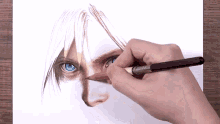 a person is drawing a face with blue eyes