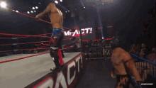 a wrestling match is taking place in front of a sign that says impact on it