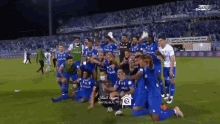 a group of soccer players wearing blue jerseys with emaar on the front