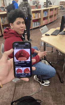 a person holding up a phone with a picture of a red angry bird on it