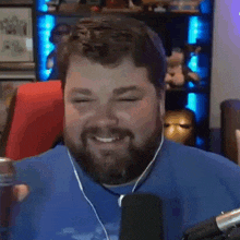 a man with a beard is smiling and holding a can of soda .