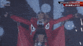 a woman in a red jacket stands in front of a large screen that says #stardom