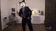 a man in a suit and tie is dancing in an office with a global hd sign in the background