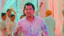 a man covered in colored powder is dancing in front of a crowd of people .