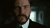 a man with a beard wearing a suit and tie