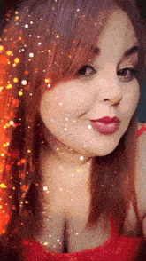a woman with red hair is wearing a red top and smiling .