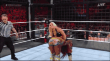 two women are wrestling in a wrestling ring with the words live on the bottom right