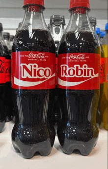 two bottles of coca cola with the name nico and robin