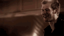 a man with a beard is smiling and looking at the camera .