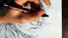 a person is drawing on a piece of paper with a red marker that says " moda " on it
