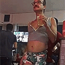 a man with a mustache and glasses is holding a glass of beer in a restaurant .