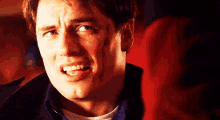 a close up of a man making a funny face with his mouth open .