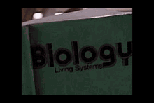 a person is reading a book about biology in a dark room .