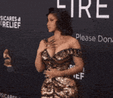 a woman in a gold dress is standing in front of a sign that says please dona