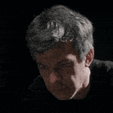 a close up of a man 's face in a dark room