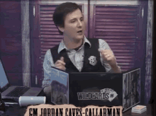 gm jordan caves callarman is sitting at a table with a laptop