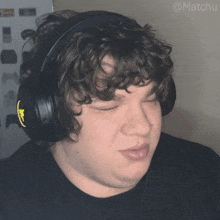 a man with curly hair wearing headphones with the hashtag matchu