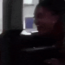 a woman is screaming in a dark room while sitting in a chair .