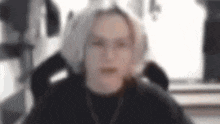 a blurry picture of a person sitting in a chair .
