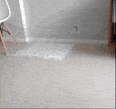 a person is standing next to a chair and a bag on the floor in a living room .