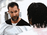 a man with dreadlocks is talking to another man in a hospital