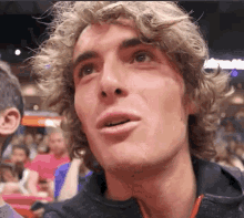 a close up of a man 's face with a crowd in the background