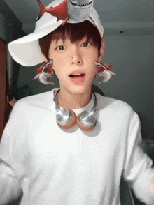 a boy wearing headphones and a shark hat