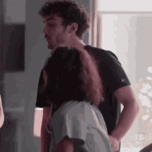 a man and a woman are standing next to each other and the woman is wearing headphones .